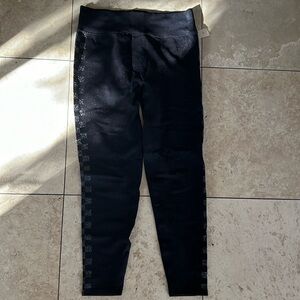 Pink seamless black leggings with checkered silver print on the sides. Size L.